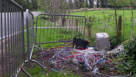 Electrical-cable,-a-suitcase-and-a-builder's-trug-illegally-fly-tipped-sometime-during-the-night-on-the-side-of-an-English-road-and-other-rubbish