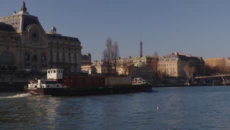 Industrial-barge-on-Seine-river-with-historical-Paris-building-in-background