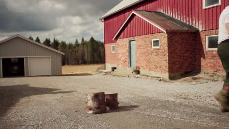 Man-Holding-And-Carrying-Firewood-Logs---Wide-Shot