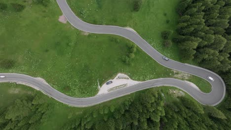 Overhead-perspective-of-vehicles-navigating-the-meandering-roads-near-Selva-Pass-in-the-Dolomite-Mountains,-Trentino,-South-Tyrol,-Italy