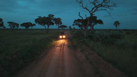 Vista-Aérea-Sobre-Un-Camión-Todoterreno-Con-Luces-De-Advertencia-Encendidas-En-La-Oscuridad-De-África