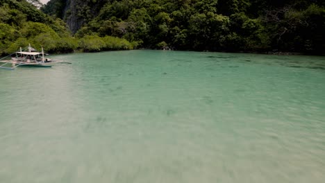 Luftaufnahme-Einer-Drohne-Aus-Der-Nähe-Von-Kristallklarem-Wasser,-Korallen-Zu-Sehen-Und-Auf-Einem-Boot-Zu-Entspannen,-Umgeben-Von-Bergen,-Klippen,-Bäumen,-Meer,-Sand-Und-Fischen-Beim-Inselhopping-In-Coron-Palawan-Auf-Den-Philippinen