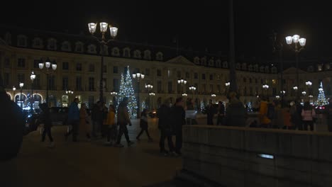 Gente-Paseando-De-Noche-Por-Las-Calles-De-París-Decoradas-Con-árboles-De-Navidad.
