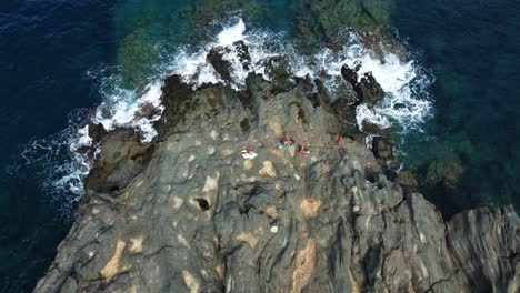 Aerial-view-above-people-having-a-picnic-on-the-cliffs-on-the-coast-of-Pantelleria,-Sicily,-Italy---top-down,-drone-shot