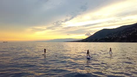 Aerial-view-of-sup-boarders,-floating-in-calm-waters-of-north-Italy---static,-drone-shot