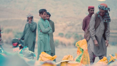 Pequeños-Niños-Paquistaníes-Esperando-La-Distribución-De-Alimentos-En-La-Unidad-Iftar-De-Baluchistán,-Pakistán