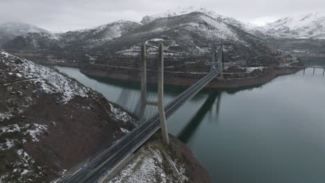 Puente-Cruza-Invierno-Valle-De-Montaña-Río-Drone-Aéreo-Embalse-De-Barrios-De-Luna-En-León,-España-Entorno-Natural-Mediterráneo