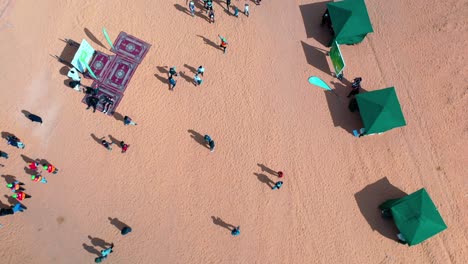 Aerial-view-of-people-at-the-Ecotrail-event,-sunny-day-in-Al-Ula,-Saudi-Arabia---rising,-tilt,-drone-shot