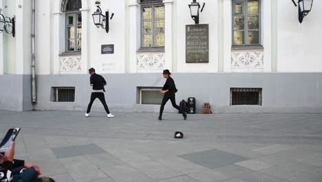 Two-young-men-dance-in-the-street-in-the-style-of-Michael-Jackson,-Nikolskaya-street