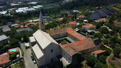 Aerial-view-circling-the-Convento-San-Domenico-in-sunny-Taggia,-Liguria,-Italy