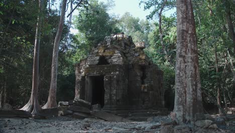 Ancient-temple-ruins-of-Angkor-Wat-surrounded-by-jungle,-stone-structure-with-trees