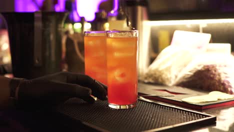 Bartender-prepares-two-tequila-sunrise-cocktails-at-the-bar