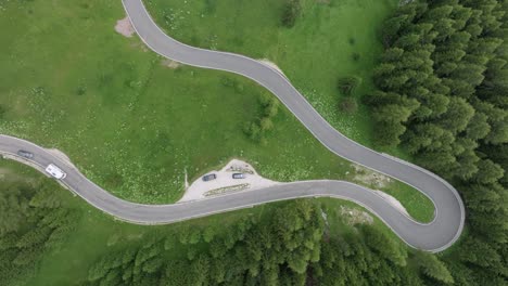 An-aerial-perspective-captures-multiple-cars-winding-through-the-forested-roads-near-Selva-Pass-in-the-Dolomite-Mountains,-Trentino,-South-Tyrol,-Italy