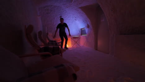 Man-Walks-Into-Salt-Cave-And-Sits-On-Chair-For-Halotherapy