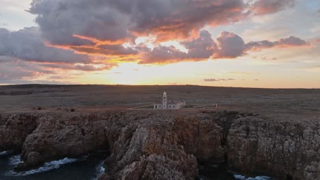 Faro-De-Punta-Nati,-Norte-De-Menorca-España-Gradiente-Tonos-Pálidos-Horizonte-Acantilado-Costa-Rocosa-Paisaje-Marino-Vista-Aérea-Drone