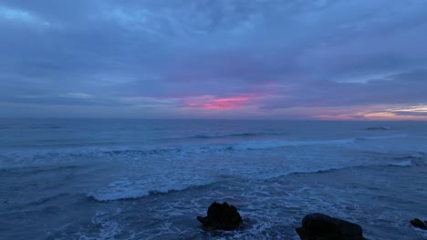 Sunset-skyline,-closeup-to-waves-arriving-shoreline-Mediterranean-Menorca-coast-pink-sky-background