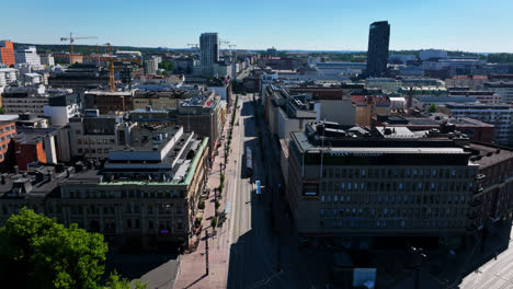 Aerial-tilt-shot-following-a-tram-on-the-streets-of-Tampere,-summer-day-in-Finland