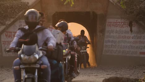 Tráfico-De-Motos-Y-Scooters-Saliendo-De-Un-Paso-Subterráneo-De-Ferrocarril-Con-Luz-Solar-Dorada-En-Gwalior,-India