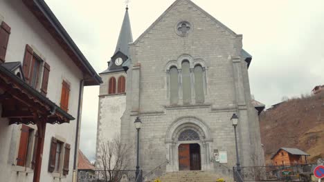 Toma-Panorámica-De-La-Iglesia-En-Un-Pueblo-Alpino-En-Los-Alpes-Franceses-Del-Ródano.