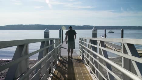 Hombre-Caminando-Hacia-Un-Muelle-Público-En-Un-Día-Soleado