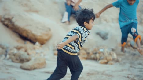 Un-Joven-Juguetón-Con-Arena-En-Las-Manos-Antes-De-Salir-Corriendo-A-La-Playa-En-Baluchistán