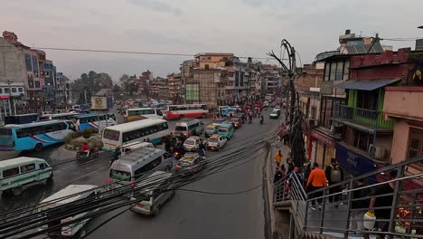 Busy-Chabahil-Intersection-Traffic,-Kathmandu:-Urban-Street-Scene-with-Cars,-Motorcycles,-and-Pedestrians---Daytime-View-of-Overpopulated-Asian-City-with-Colorful-Shops-and-Smog