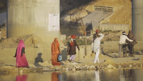 Pilger-Oder-Eine-Gruppe-Von-Dorfbewohnern-Der-Bundelkhand-Kultur,-Die-Am-Ufer-Eines-Sindh-Flusses-Unter-Einer-Brücke-Spazieren