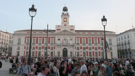 Wide-view-of-large-crowds-of-people-gathering-and-spending-their-evening-at-the-Puerta-del-Sol,-an-iconic-landmark-of-Madrid