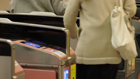 Shibuya-Train-Station,-Commuters-walking-through-ticket-gates,-Tokyo,-Japan