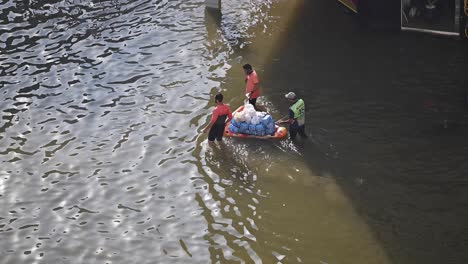 On-April-19,-2024,-groceries-are-delivered-by-boat-on-a-flooded-road-in-the-northern-UAE-after-record-rain-hit-the-country