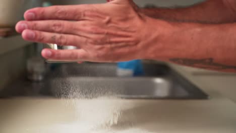 Slowmotion-caucasian-hand-sifts-white-flour-with-a-sieve-interior-kitchen