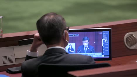 A-lawmaker-listens-to-John-Lee-Ka-chiu,-Hong-Kong's-chief-executive,-delivering-the-annual-policy-address-at-the-Legislative-Council-main-chamber-in-Hong-Kong