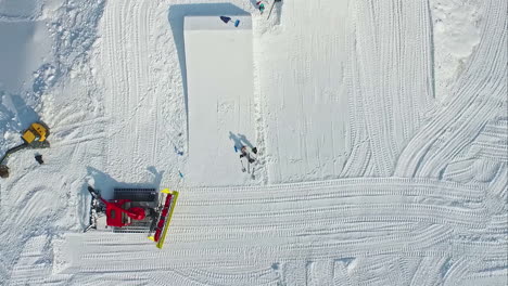 -Schneepflug-Macht-Ski--Und-Snowboardsprünge-In-Einem-Skigebiet---Luftaufnahme-Geradeaus-Nach-Unten