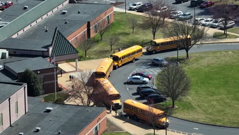 Children-and-student-leaving-school-and-entering-parked-iconic-yellow-school-bus-in-USA