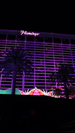 Las-Vegas,-EE.UU.,-Vídeo-Vertical,-Hotel-Casino-Flamingo-Por-La-Noche,-Tráfico-Y-Luces-De-Colores