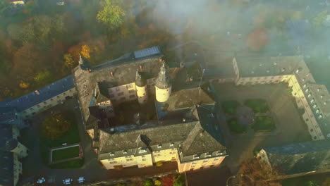 Tilted-aerial-view-over-Birstein-Castle-in-Germany-on-a-cloudy-day