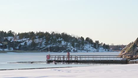 Two-ice-swimmers-getting-into-water-on-a-sunny-winter-afternoon