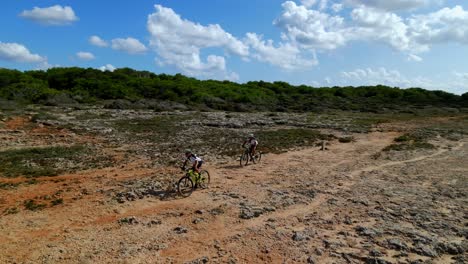 Los-Ciclistas-De-BTT-Que-Corren-A-Lo-Largo-De-La-Costa-De-Menorca,-España,-Encuentran-Un-Desafío-Los-Duros-Elementos-Del-Terreno-Rocoso.