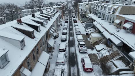 Aerial-birds-eye-flight-over-snowy-dense-populated-street-in-american-suburbia