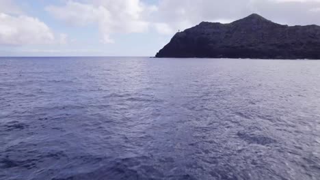 drone-shot-across-flying-low-across-the-Pacific-ocean-approaching-the-rocky-cliffs-of-Kaohikaipu-island-off-the-coast-of-Oahu-Hawaii