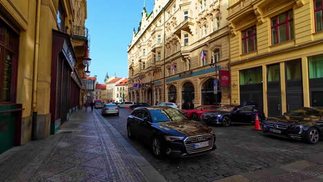 POV-shot-while-walking-through-the-streets-of-Prague,-Czech-Republic-on-an-early-morning-with-cars-parked-along-the-roadside