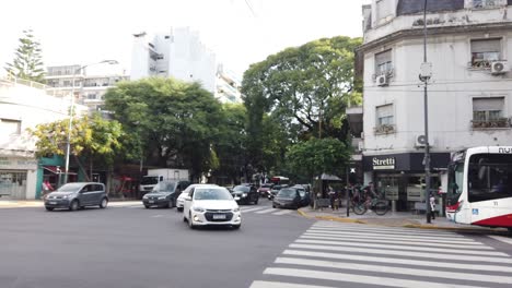 Cars-drive-turning-at-Directorio-avenue-fast-lane-of-buenos-aires-city-in-autumn-argentine-public-transport-bus-waiting-in-stop-traffic-lights-panoramic-cityscape-view