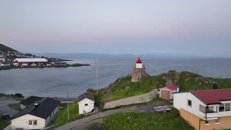 Honningsvag,-Norway,-Aerial-View-of-Small-Lighthouse-on-Hill-Above-Coast,-Drone-Shot-60fps