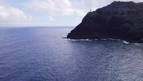 Drohnenaufnahmen-Vom-Leuchtturm-Makapu&#39;u-Point-Auf-Einer-Steilen-Klippe-Mit-Blick-Auf-Das-Blaue-Wasser-Des-Pazifischen-Ozeans-Und-Die-Weißen-Wellen,-Die-Auf-Die-Felsige-Küste-Unterhalb-Von-Oahu,-Hawaii,-Krachen