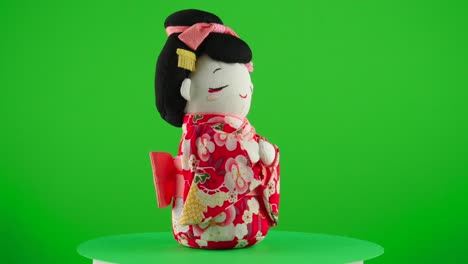 Kimono-Rojo-Con-Muñeca-Geisha-Sakura-Maiko-Hecha-A-Mano-Regalo-Tradicional-Japonés-Presente-En-Un-Plato-Giratorio-Con-Pantalla-Verde-Para-Eliminar-El-Fondo