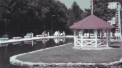 Pavillon-Und-Geländer-An-Einem-See-Tagsüber-An-Einem-Ruhigen,-Sonnigen-Tag-In-Den-1930er-Jahren