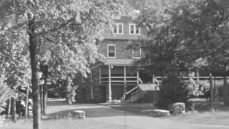 Vintage-Schwarzweißaufnahmen-Eines-Klassischen-Hauses,-Umgeben-Von-Bäumen-In-Den-1930er-Jahren