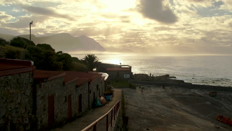 Golden-sunrise-god-rays-through-clouds-over-Walker-Bay,-view-from-Old-Harbour