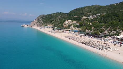 Kathisma-Beach-Auf-Der-Insel-Lefkada-Bietet-Besuchern-Einen-Sandstrand-Mit-Sonnenschirmen-Und-Sanften-Türkisfarbenen-Meereswellen