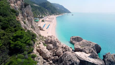 The-popular-Kathisma-Beach-on-the-Greek-island-of-Lefkada-with-blue-sea-and-rows-of-umbrellas,-Greece